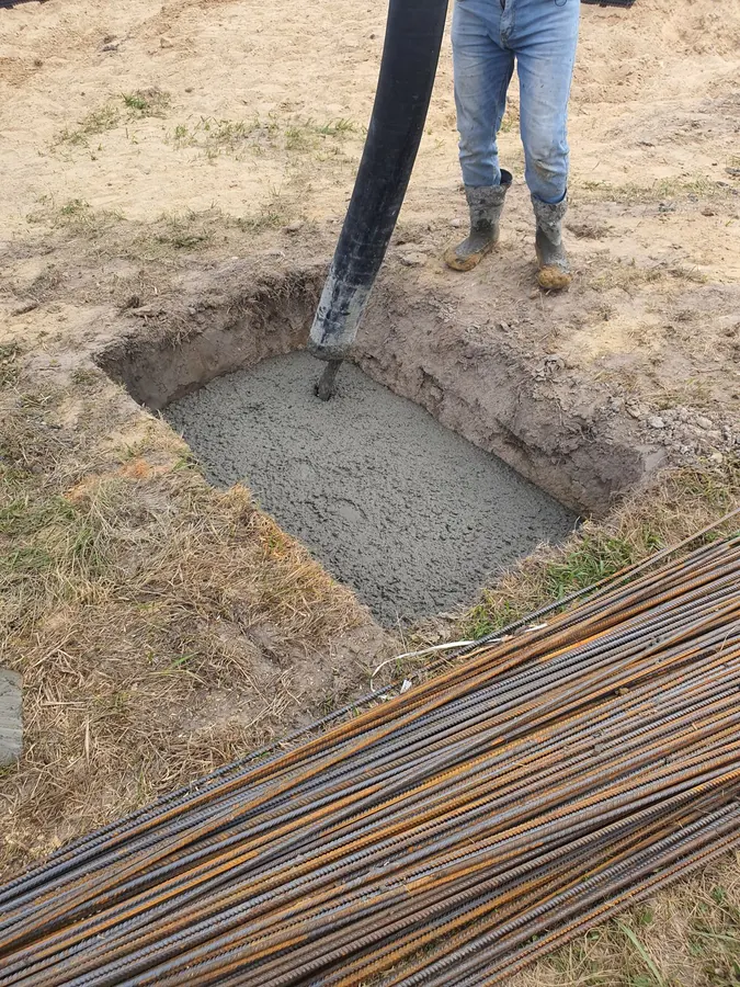 Concrete placed into a footing beside bundled rebar