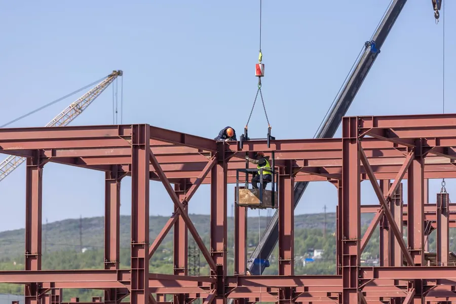 Structural steel frame being erected under clear sky